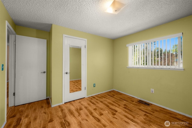 33046 38th Ave SW, Federal Way, WA 98023 - unfurnished bedroom featuring wood finished floors and a textured ceiling
