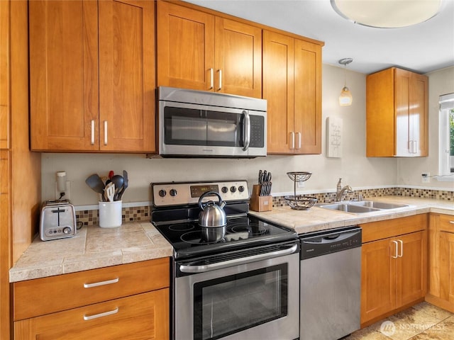 8828 S K St, Tacoma, WA 98444 - kitchen featuring appliances with stainless steel finishes, a sink, tile counters, and brown cabinets