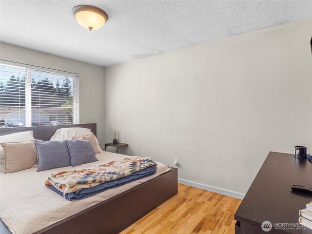 8828 S K St, Tacoma, WA 98444 - bedroom featuring wood finished floors, a textured ceiling, and baseboards