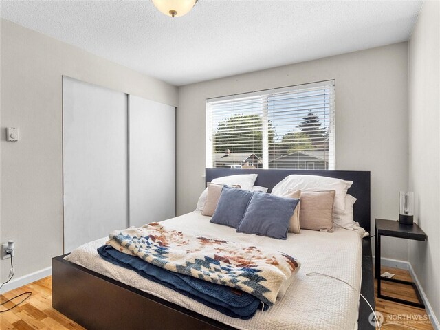 8828 S K St, Tacoma, WA 98444 - bedroom featuring wood finished floors, a closet, baseboards, and a textured ceiling