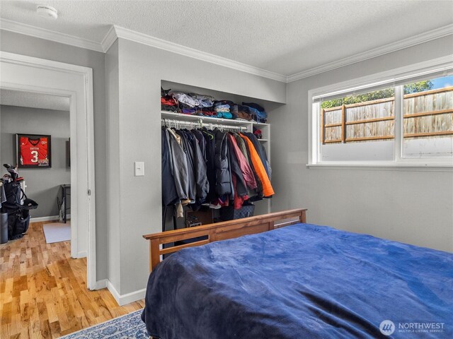 8828 S K St, Tacoma, WA 98444 - bedroom featuring wood finished floors, crown molding, baseboards, a closet, and a textured ceiling