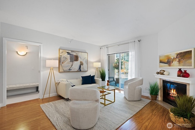 2331 42nd Ave SW Unit 206, Seattle, WA 98116 - living room featuring wood finished floors, a glass covered fireplace, and baseboards