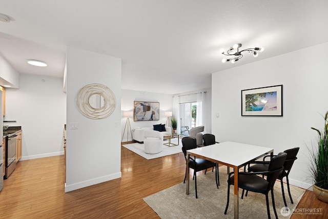 2331 42nd Ave SW Unit 206, Seattle, WA 98116 - dining area with light wood-style flooring and baseboards