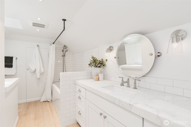 106 W Mcgraw St, Seattle, WA 98119 - full bathroom featuring vanity, shower / bathtub combination with curtain, vaulted ceiling, recessed lighting, and wood finished floors