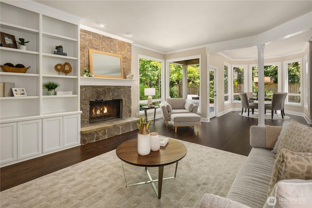 2260 269th Ct SE, Sammamish, WA 98075 - living room featuring wood finished floors, crown molding, a stone fireplace, ornate columns, and baseboards