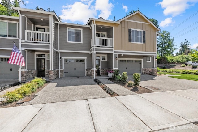 8603 E Gilman Ave, Arlington, WA 98223 - view of front facade featuring a balcony, driveway, an attached garage, stone siding, and board and batten siding