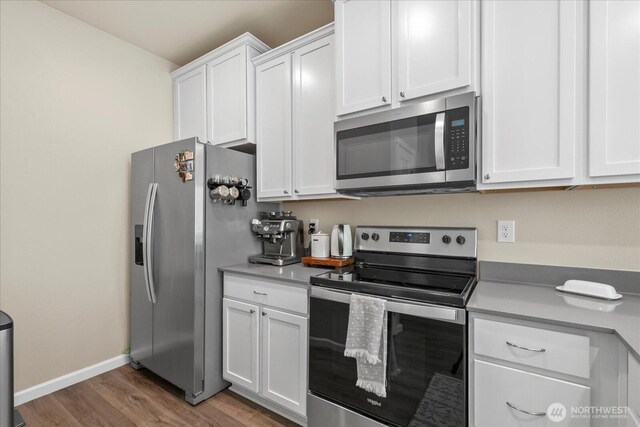 8603 E Gilman Ave, Arlington, WA 98223 - kitchen with stainless steel appliances, wood finished floors, white cabinets, and baseboards