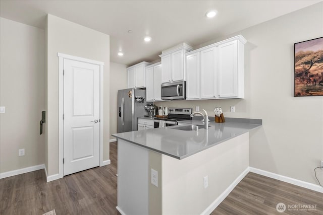 8603 E Gilman Ave, Arlington, WA 98223 - kitchen with stainless steel appliances, a sink, dark wood-style floors, baseboards, and white cabinetry