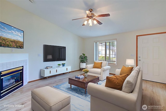 712 SE 5th Way, Battle Ground, WA 98604 - living room featuring ceiling fan, wood finished floors, a fireplace, vaulted ceiling, and baseboards