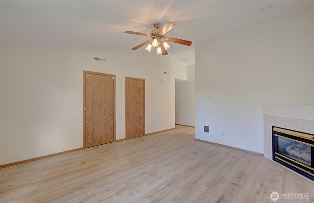 712 SE 5th Way, Battle Ground, WA 98604 - unfurnished living room with lofted ceiling, wood finished floors, a ceiling fan, a tile fireplace, and baseboards
