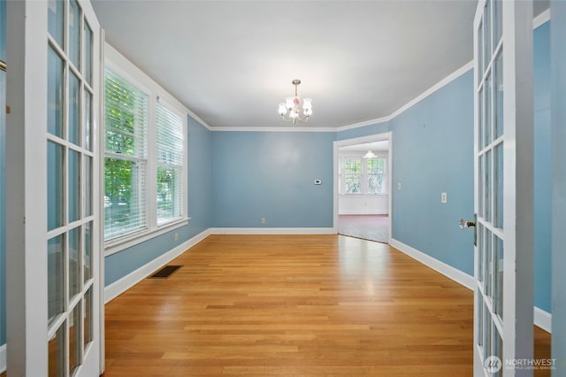 827 Hobson St, Walla Walla, WA 99362 - unfurnished room with a chandelier, wood finished floors, crown molding, french doors, and baseboards