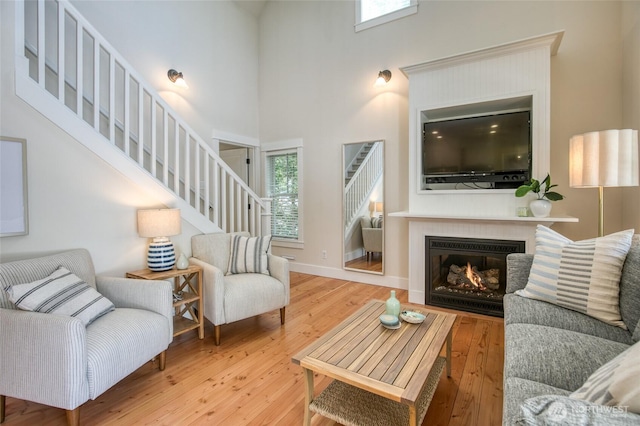 191 Compass St, Pacific Beach, WA 98571 - living area with a high ceiling, stairway, hardwood / wood-style floors, and a glass covered fireplace