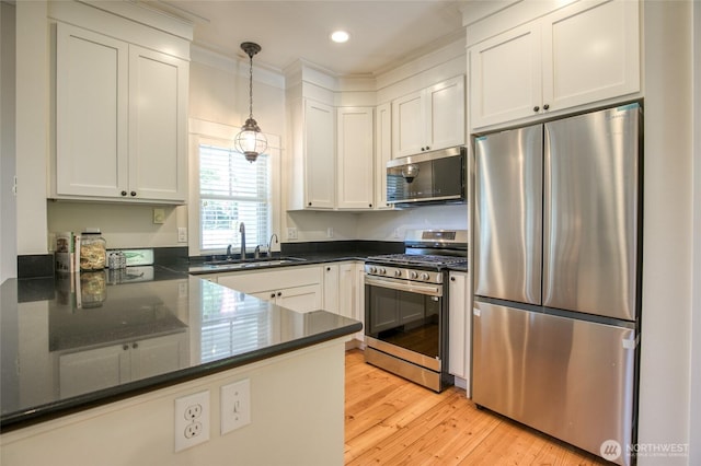 191 Compass St, Pacific Beach, WA 98571 - kitchen with appliances with stainless steel finishes, pendant lighting, light wood-style flooring, white cabinetry, and recessed lighting