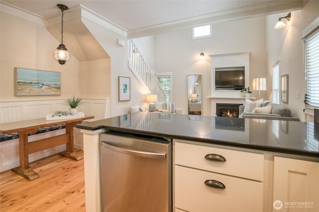 191 Compass St, Pacific Beach, WA 98571 - kitchen featuring stainless steel dishwasher, crown molding, dark countertops, open floor plan, and light wood-type flooring