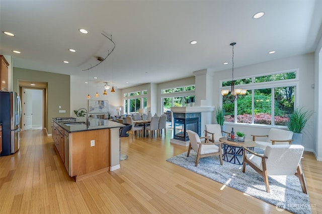 22879 NE 127th Way, Redmond, WA 98053 - kitchen featuring stainless steel fridge, a sink, dark countertops, light wood-style floors, and recessed lighting