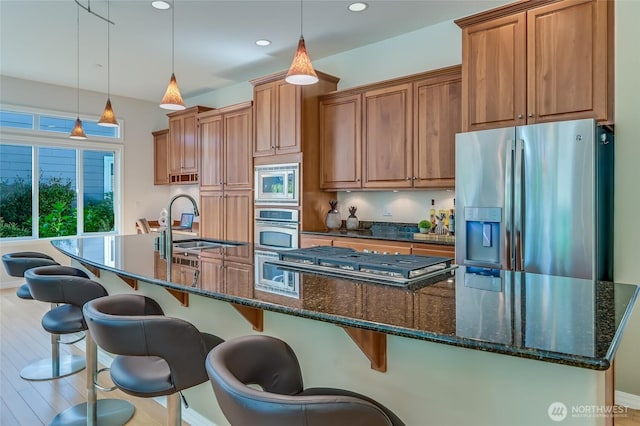 22879 NE 127th Way, Redmond, WA 98053 - kitchen featuring stainless steel appliances, a large island, a sink, brown cabinets, and recessed lighting