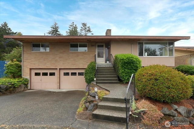 11847 78th Ave S, Seattle, WA 98178 - view of front of home with an attached garage, driveway, stairs, and brick siding