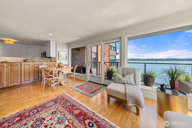 2360 43rd Ave E Unit 213, Seattle, WA 98112 - living area featuring light wood-style floors, french doors, a water view, and recessed lighting