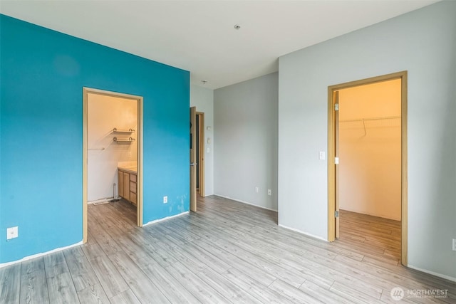 4724 Mill Pond Dr SE Unit 702, Auburn, WA 98092 - unfurnished bedroom featuring a walk in closet, light wood-style floors, a closet, and ensuite bathroom