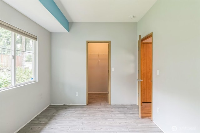 4724 Mill Pond Dr SE Unit 702, Auburn, WA 98092 - unfurnished bedroom with multiple windows, a spacious closet, light wood-style flooring, and a closet