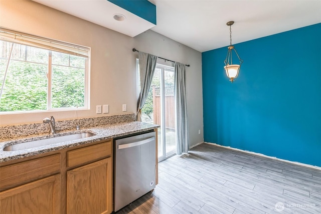 4724 Mill Pond Dr SE Unit 702, Auburn, WA 98092 - kitchen featuring stainless steel dishwasher, a sink, hanging light fixtures, light wood-type flooring, and light stone countertops
