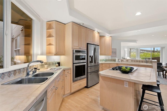 3900 2nd Ave NE Unit 204, Seattle, WA 98105 - kitchen with light brown cabinetry, appliances with stainless steel finishes, a sink, open shelves, and backsplash