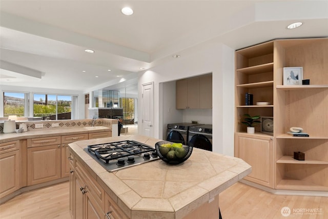 3900 2nd Ave NE Unit 204, Seattle, WA 98105 - kitchen featuring stainless steel gas cooktop, open shelves, washing machine and dryer, tile counters, and recessed lighting