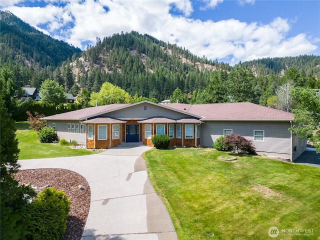 10552 Ski Hill Dr, Leavenworth, WA 98826 - ranch-style home with a mountain view, a wooded view, concrete driveway, and a front lawn