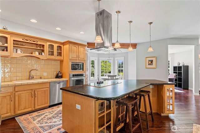 10552 Ski Hill Dr, Leavenworth, WA 98826 - kitchen featuring stainless steel appliances, a sink, island exhaust hood, a kitchen bar, and hardwood / wood-style flooring