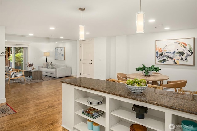1414 1st Ave W Unit 104, Seattle, WA 98119 - kitchen with light wood-type flooring, open shelves, dark stone counters, decorative light fixtures, and recessed lighting