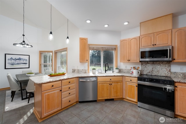 18311 Burn Rd, Arlington, WA 98223 - kitchen featuring appliances with stainless steel finishes, a sink, a peninsula, light stone countertops, and light brown cabinetry
