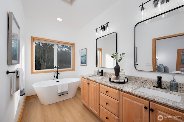 18311 Burn Rd, Arlington, WA 98223 - full bathroom featuring wood finished floors, double vanity, a soaking tub, ensuite bath, and baseboards