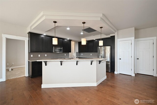 627 68th Ave E, Tacoma, WA 98424 - kitchen with stainless steel appliances, dark cabinetry, a kitchen breakfast bar, and recessed lighting