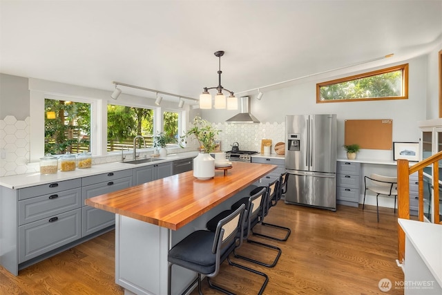 4819 S Lucile St, Seattle, WA 98118 - kitchen featuring appliances with stainless steel finishes, gray cabinets, wooden counters, a sink, and wall chimney range hood