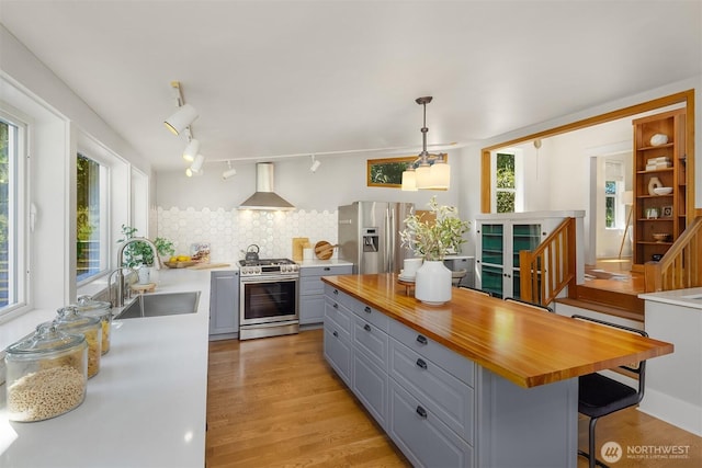 4819 S Lucile St, Seattle, WA 98118 - kitchen with stainless steel appliances, gray cabinetry, wall chimney range hood, and butcher block countertops