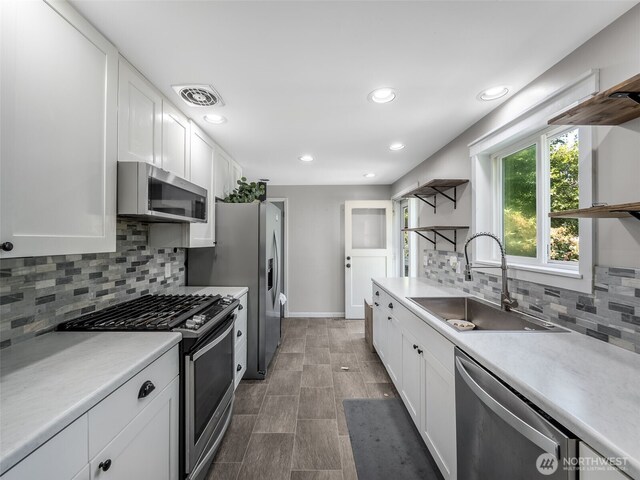 2134 SW 339th St, Federal Way, WA 98023 - kitchen with stainless steel appliances, a sink, open shelves, white cabinets, and backsplash