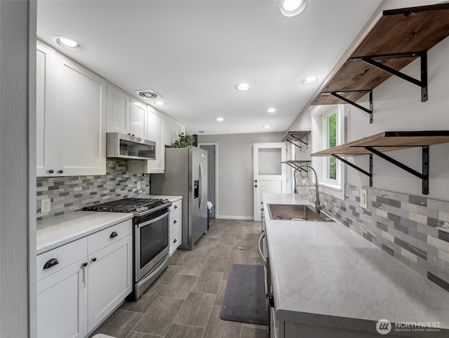 2134 SW 339th St, Federal Way, WA 98023 - kitchen with appliances with stainless steel finishes, a sink, backsplash, white cabinetry, and recessed lighting