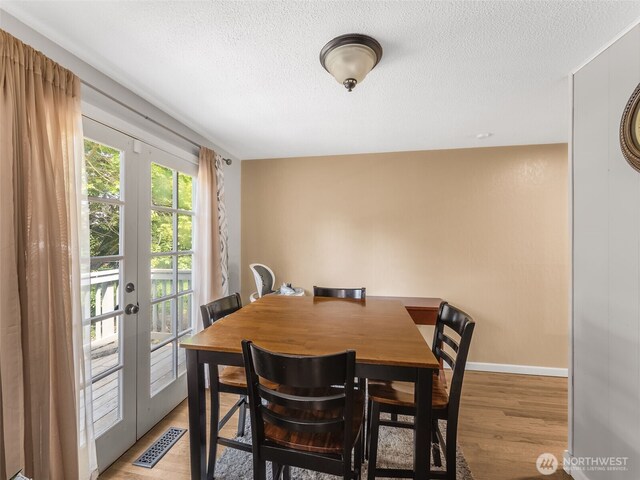 2134 SW 339th St, Federal Way, WA 98023 - dining area with a textured ceiling, light wood finished floors, baseboards, and french doors