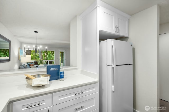 12721 NE 116th St Unit F102, Kirkland, WA 98034 - kitchen with freestanding refrigerator, healthy amount of natural light, white cabinetry, and light countertops