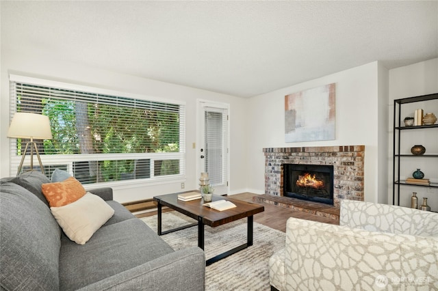 12721 NE 116th St Unit F102, Kirkland, WA 98034 - living area featuring a brick fireplace, wood finished floors, and baseboards