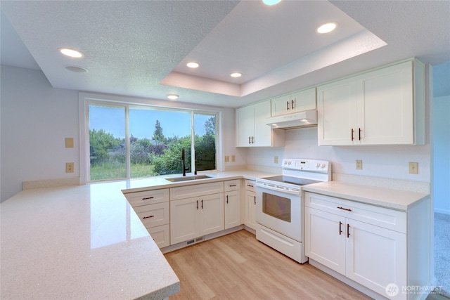 2320 183rd Street Ct E, Tacoma, WA 98445 - kitchen with white electric stove, under cabinet range hood, a sink, a tray ceiling, and recessed lighting