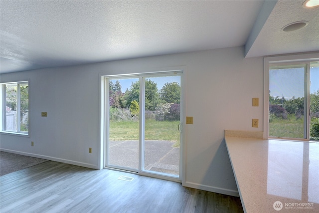 2320 183rd Street Ct E, Tacoma, WA 98445 - unfurnished dining area with wood finished floors, baseboards, and a textured ceiling