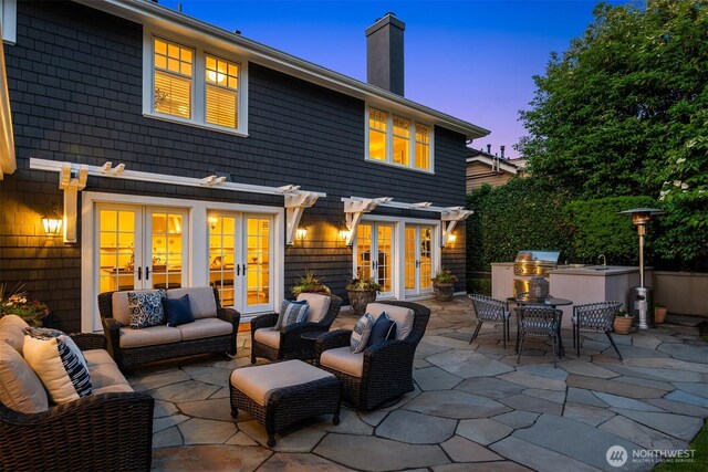 1325 Broadmoor Dr E, Seattle, WA 98112 - back of property featuring french doors, exterior kitchen, an outdoor hangout area, a chimney, and a patio