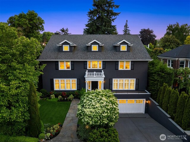1325 Broadmoor Dr E, Seattle, WA 98112 - view of front of house with a garage, driveway, a chimney, a front lawn, and roof with shingles