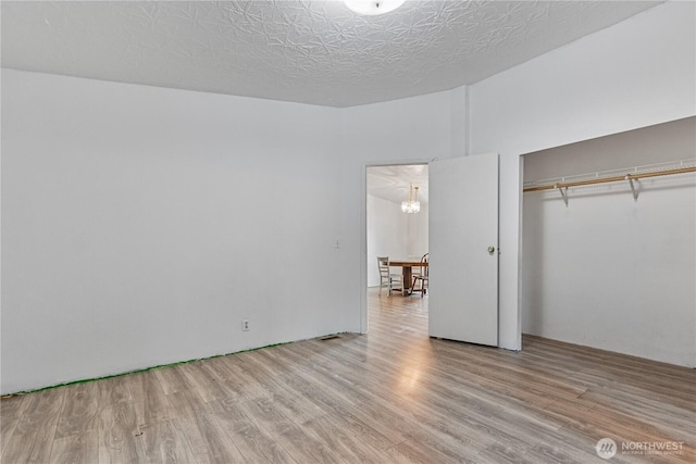 8530 Steilacoom Rd SE Unit 113, Olympia, WA 98513 - unfurnished bedroom with wood finished floors, a closet, and a chandelier