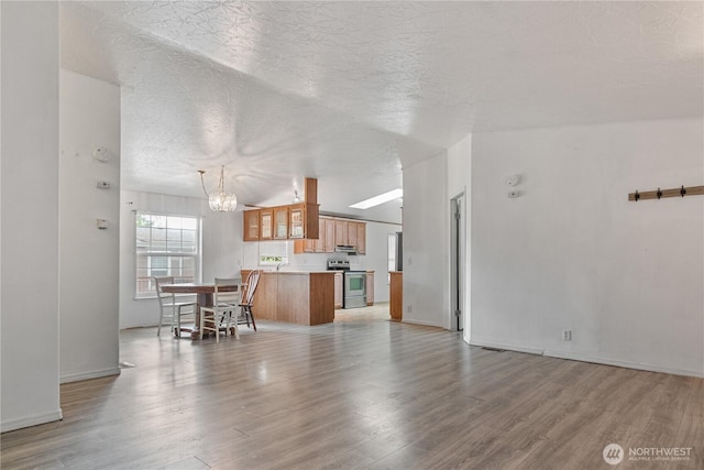 8530 Steilacoom Rd SE Unit 113, Olympia, WA 98513 - living room featuring a chandelier, light wood-style flooring, a textured ceiling, and baseboards