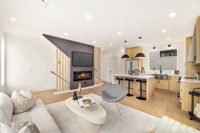4515 44th Ave SW Unit A, Seattle, WA 98116 - living room featuring light wood-style flooring, a large fireplace, recessed lighting, and baseboards