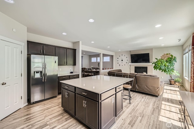 12726 36th Pl NE, Lake Stevens, WA 98258 - kitchen featuring stainless steel fridge, light wood-style flooring, a center island, light countertops, and a kitchen breakfast bar