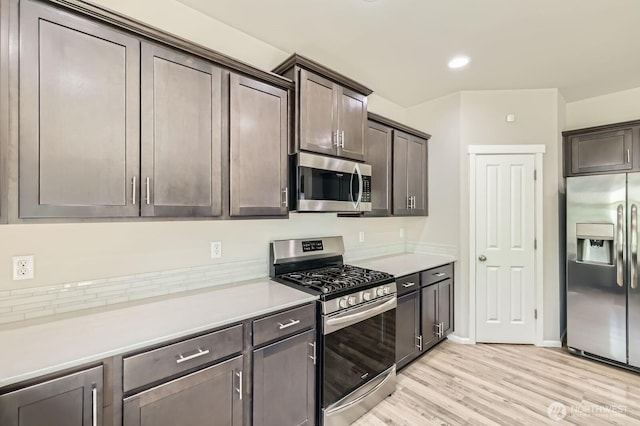 12726 36th Pl NE, Lake Stevens, WA 98258 - kitchen with stainless steel appliances, dark brown cabinetry, light countertops, and light wood finished floors