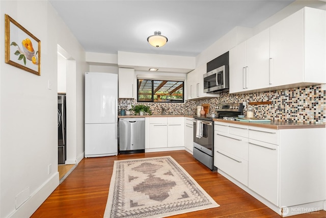 4742 22nd Ave SW, Seattle, WA 98106 - kitchen with appliances with stainless steel finishes, decorative backsplash, and white cabinetry